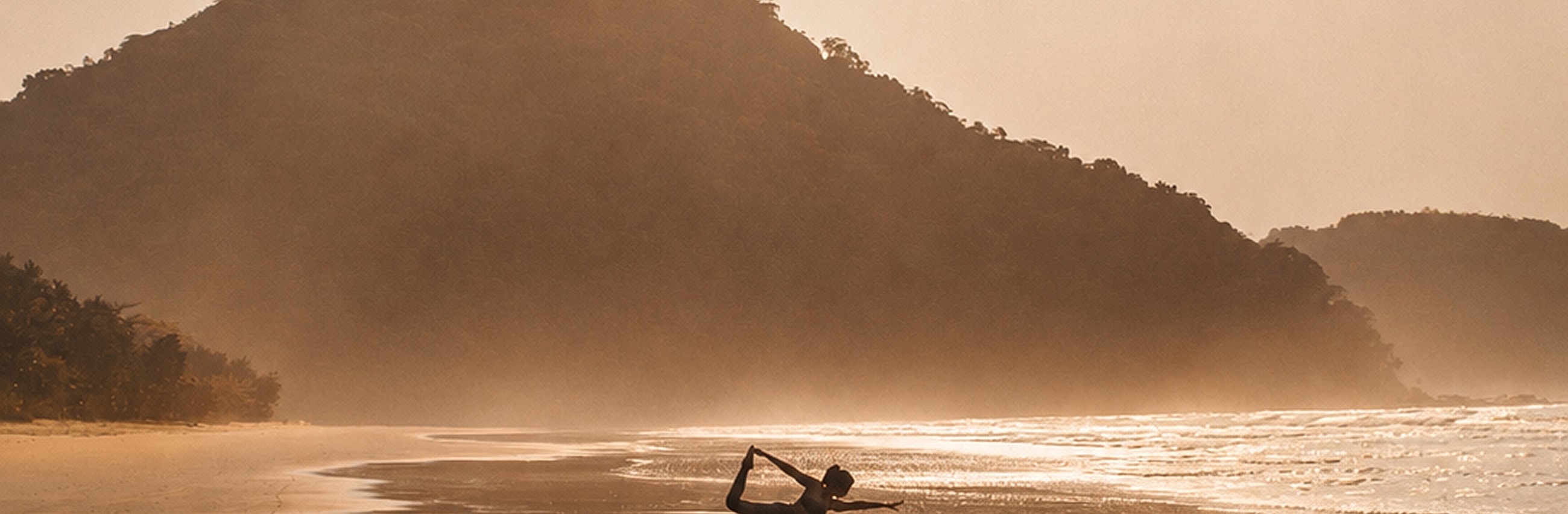 Person practicing yoga on a serene beach.