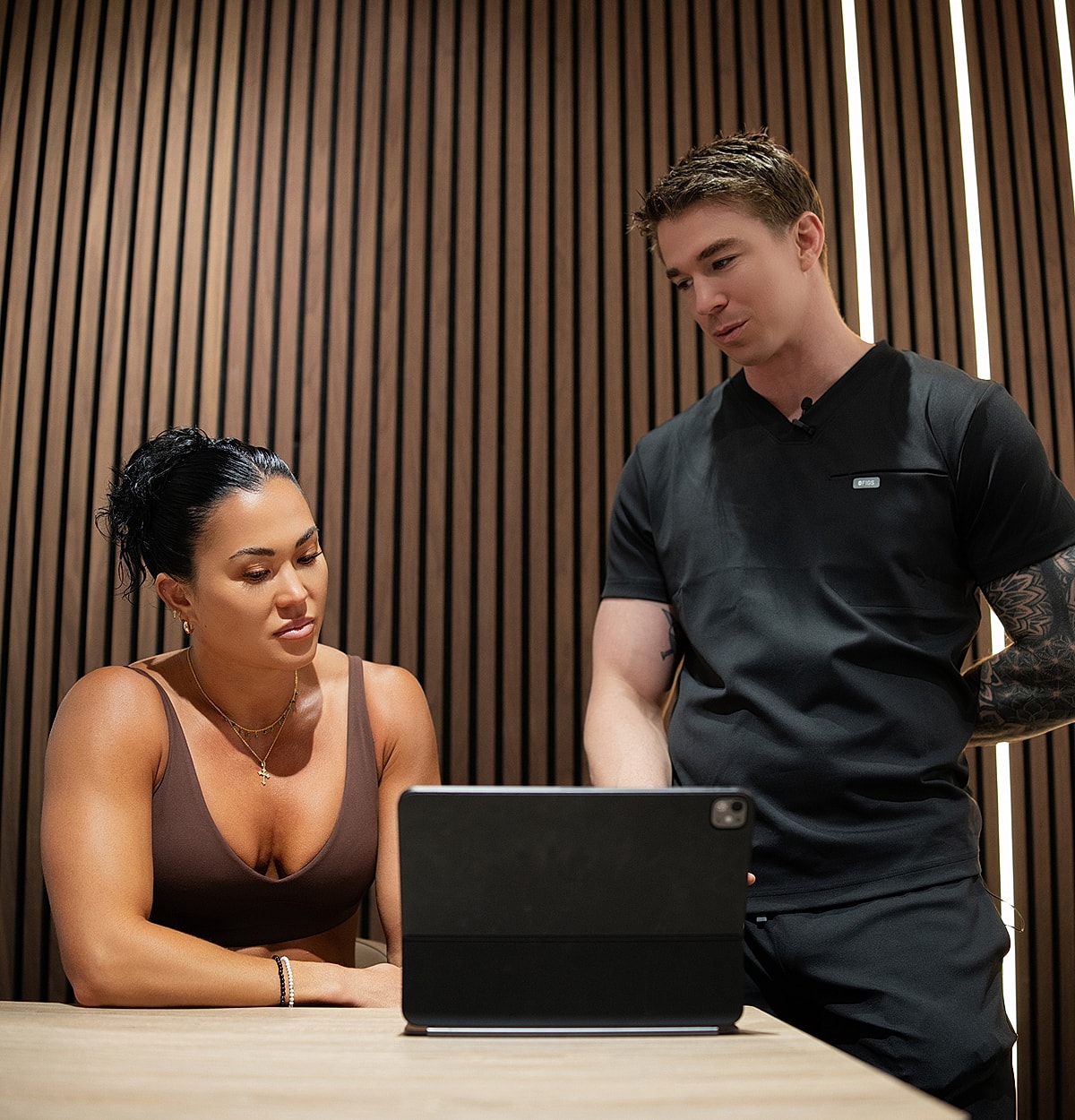 Two people discussing over a tablet.