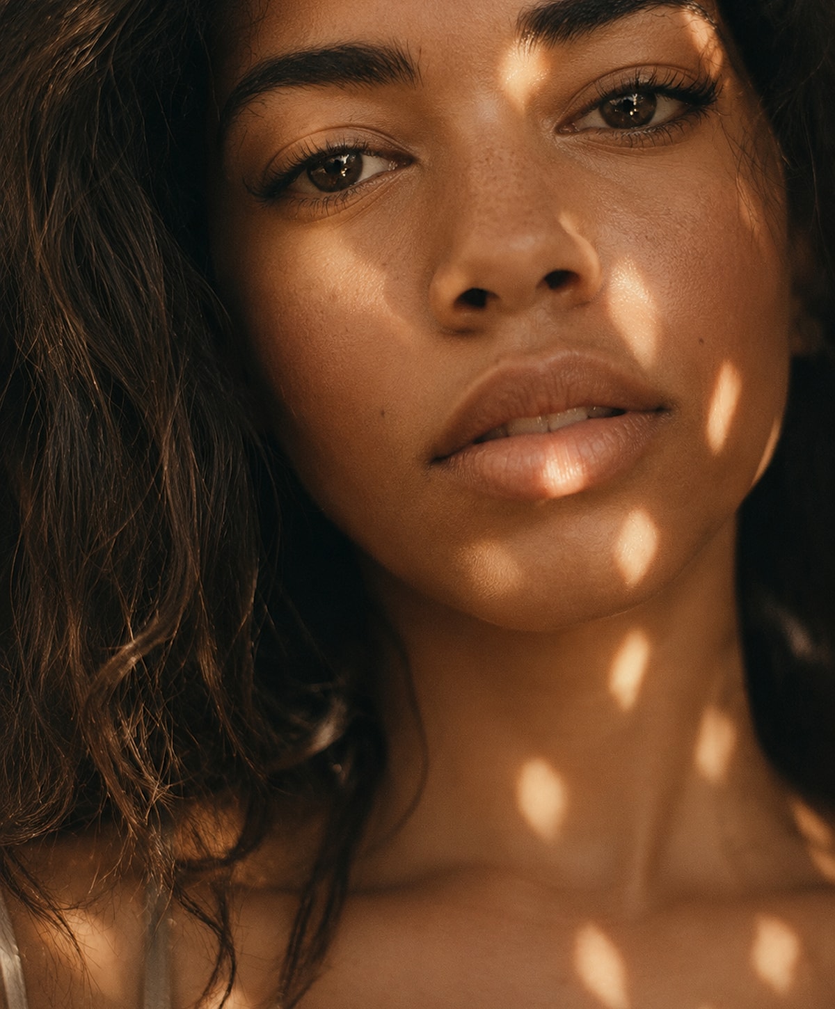 Woman's face with soft natural lighting and shadows.