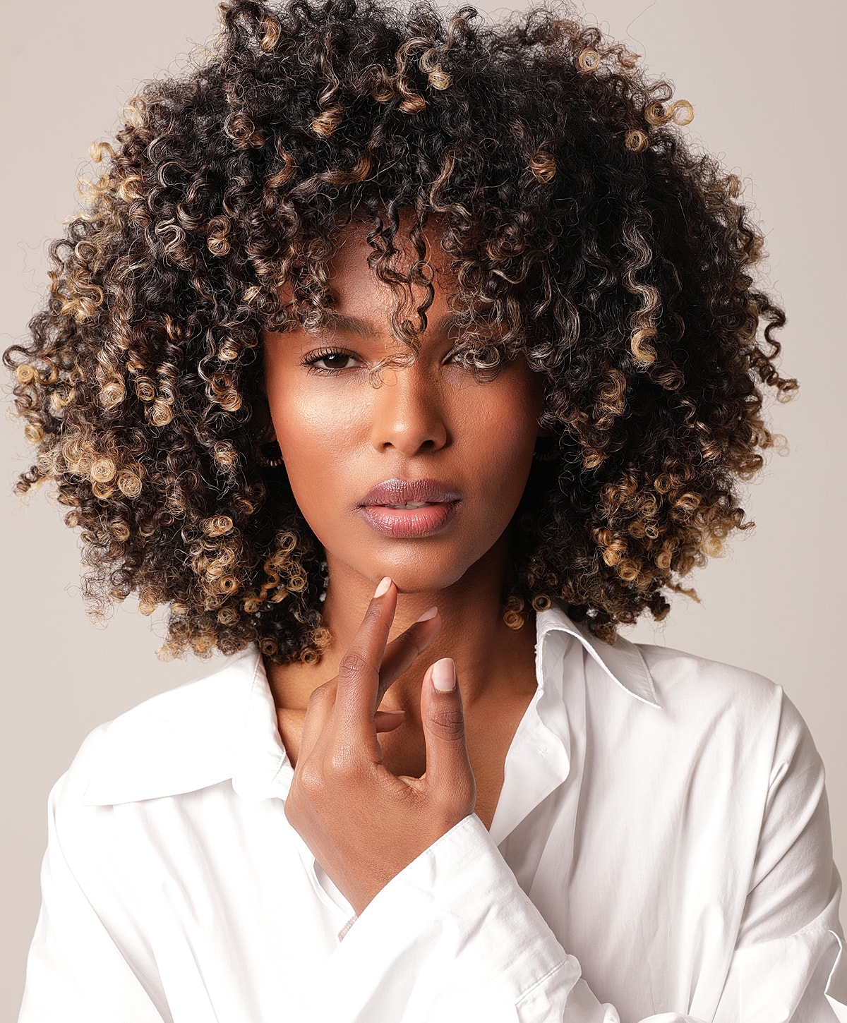 Woman with curly hair in white shirt.