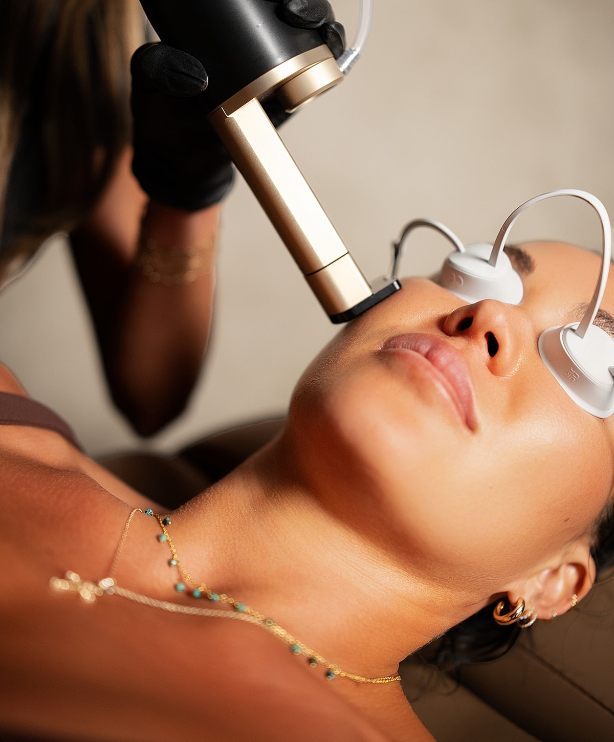 Facial treatment with beauty device in progress.