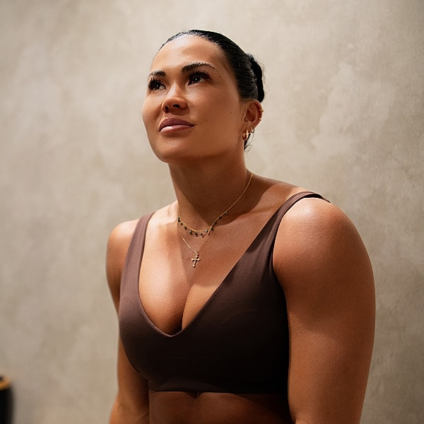 Woman in athletic wear gazing upward thoughtfully.