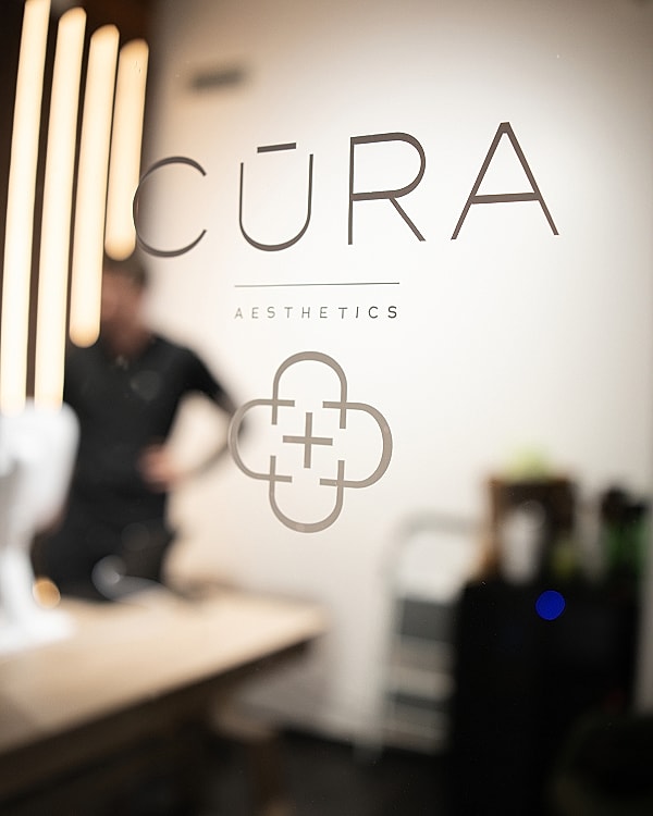 CūRA Aesthetics logo on studio door.