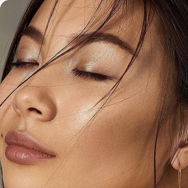 Close-up of a woman with glowing skin.