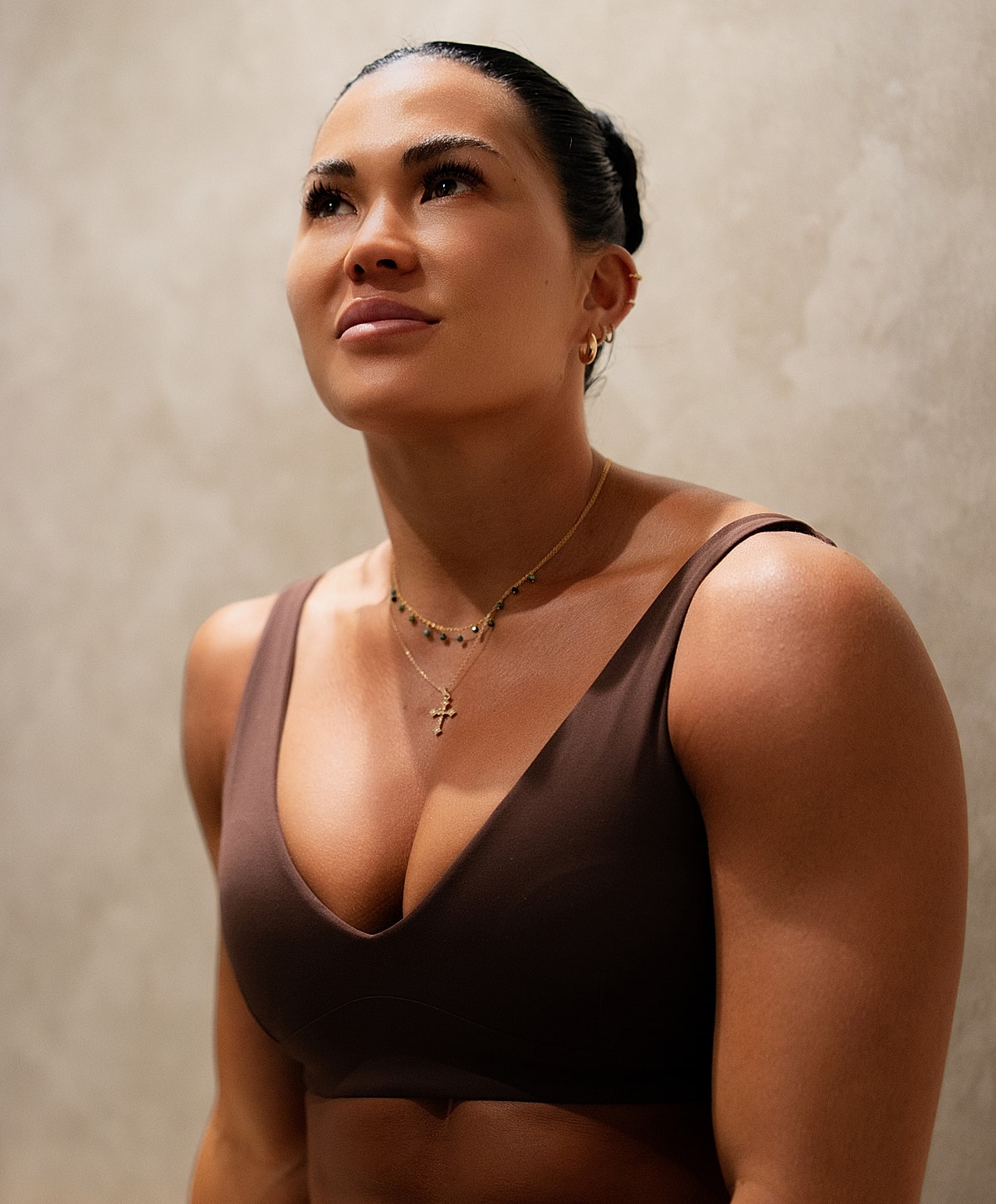 Woman looking upward against a neutral background.