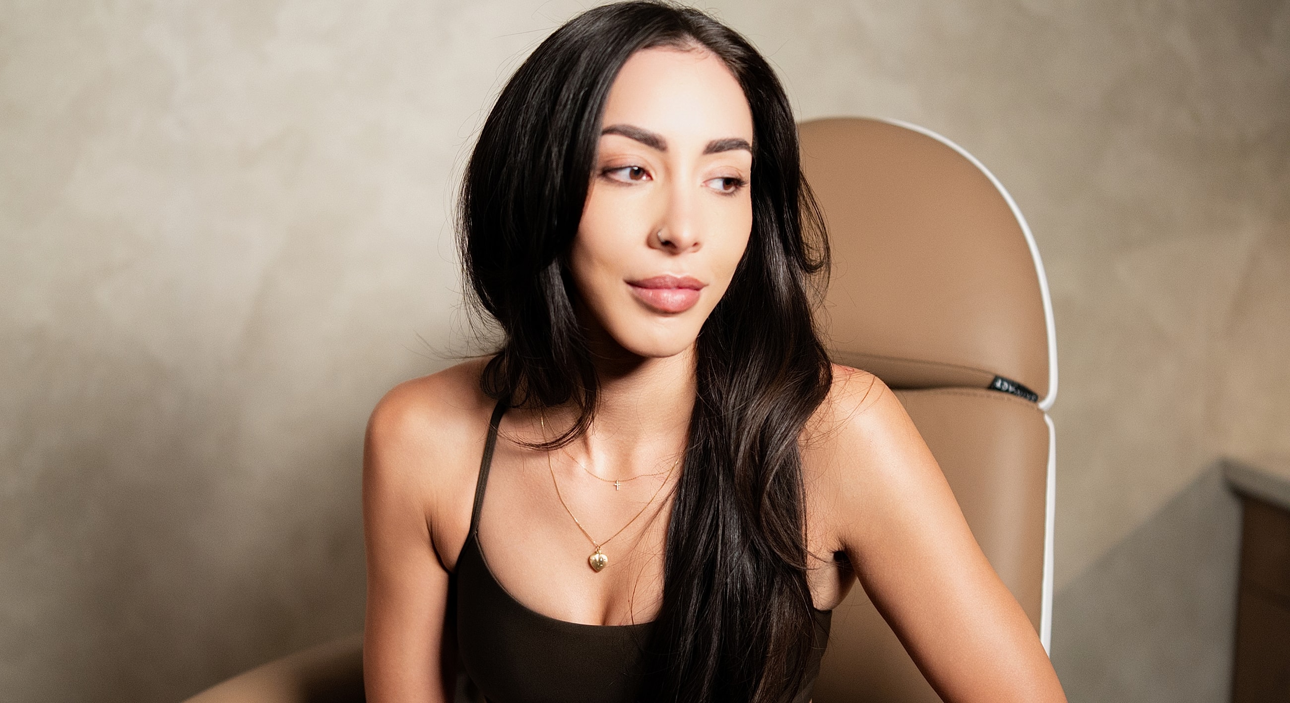 Woman with long hair in a neutral setting.